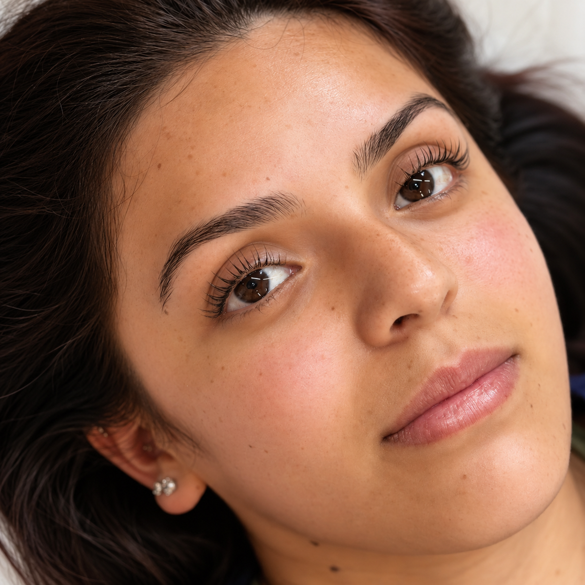 Close-up of softly lifted natural lashes and groomed brows