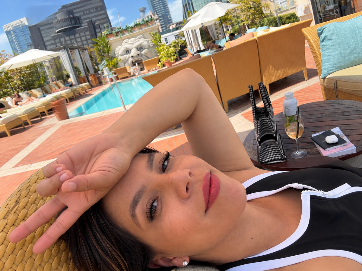 Renee enjoying a sunny day by a rooftop pool